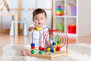 baby,girl,playing,with,educational,toy,in,nursery