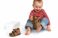 Small,child,tries,to,put,on,his,shoes.,baby,boy