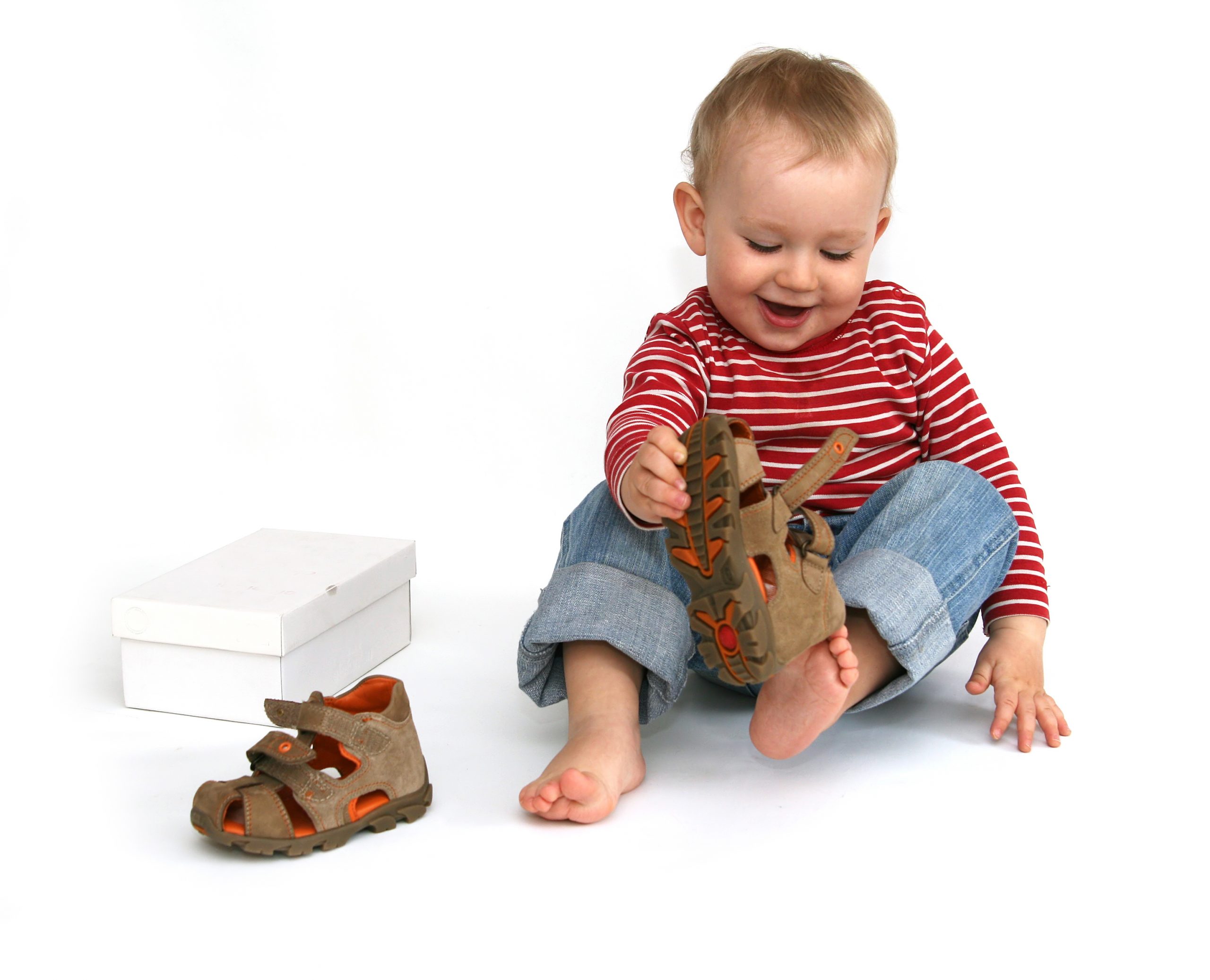 Small,child,tries,to,put,on,his,shoes.,baby,boy