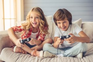 pretty,little,girl,and,boy,are,playing,game,console,and