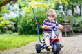 active,blond,kid,boy,driving,tricycle,or,bicycle,in,domestic