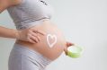 a,pregnant,woman,applies,stretch,marks,cream,to,her,stomach.