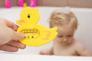 father`s,holding,a,bath,thermometer.,little,child,taking,a,bath