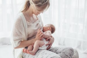 bright,portrait,of,a,mom,breast,feeding,baby,over,window