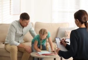 child,psychotherapist,working,with,little,girl,and,her,father,in