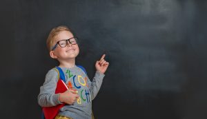 back,to,school.,funny,little,boy,in,glasses,pointing,up