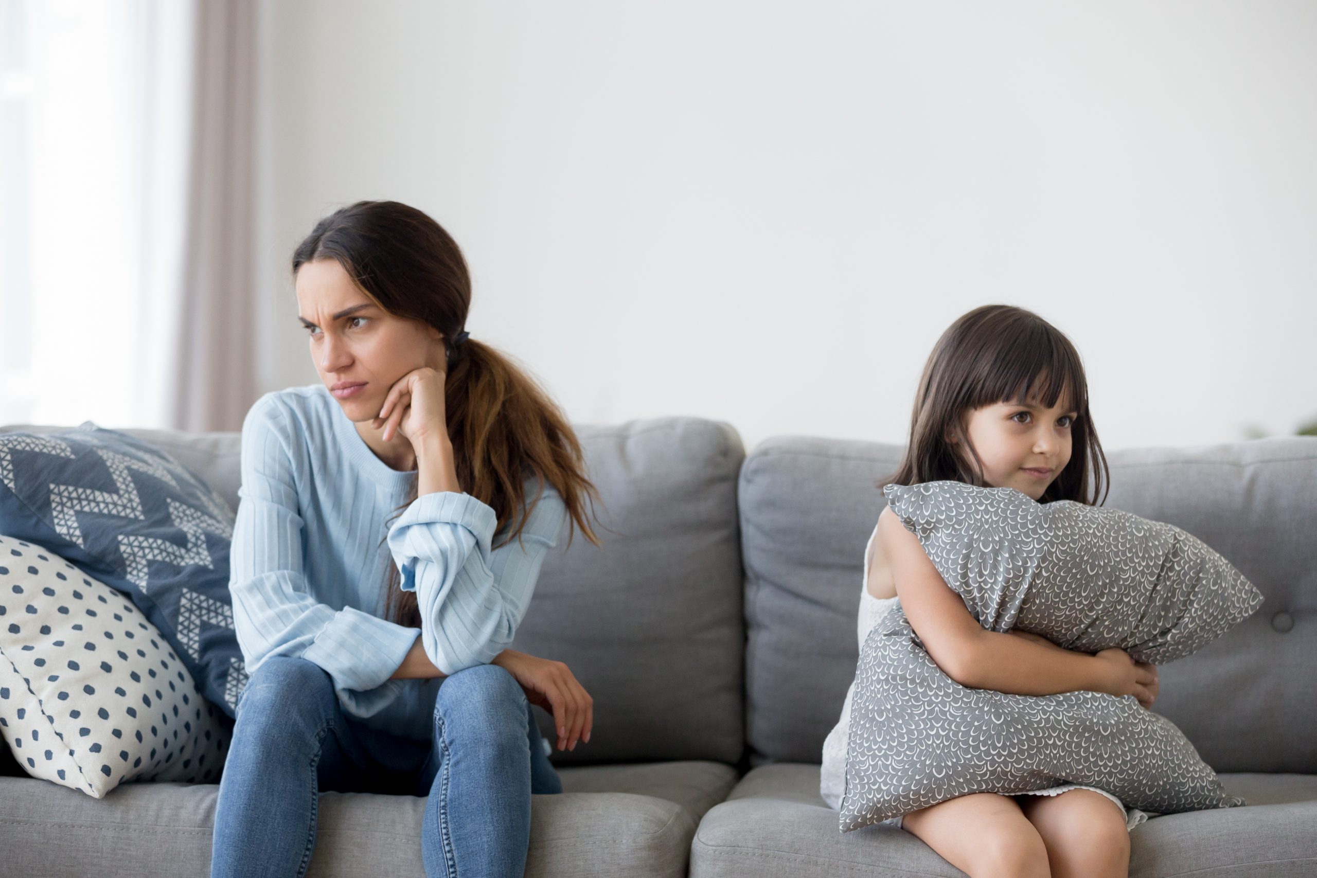 mother,and,little,daughter,after,quarrelling,sitting,together,on,couch