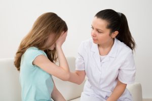 female,doctor,in,labcoat,comforting,patient,crying,in,hospital